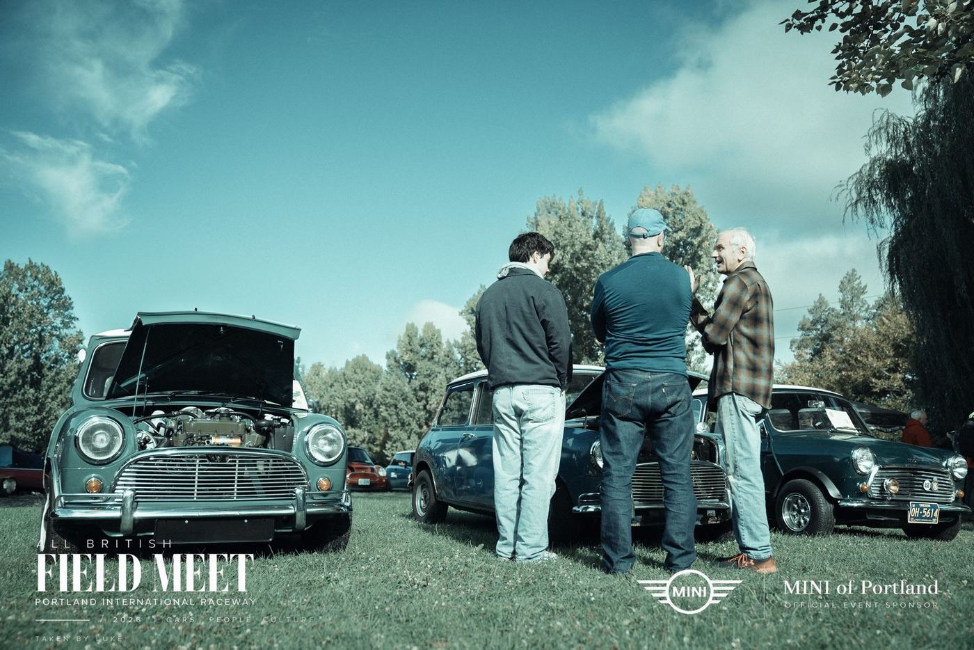 Three men talking over an open Mini engine bay