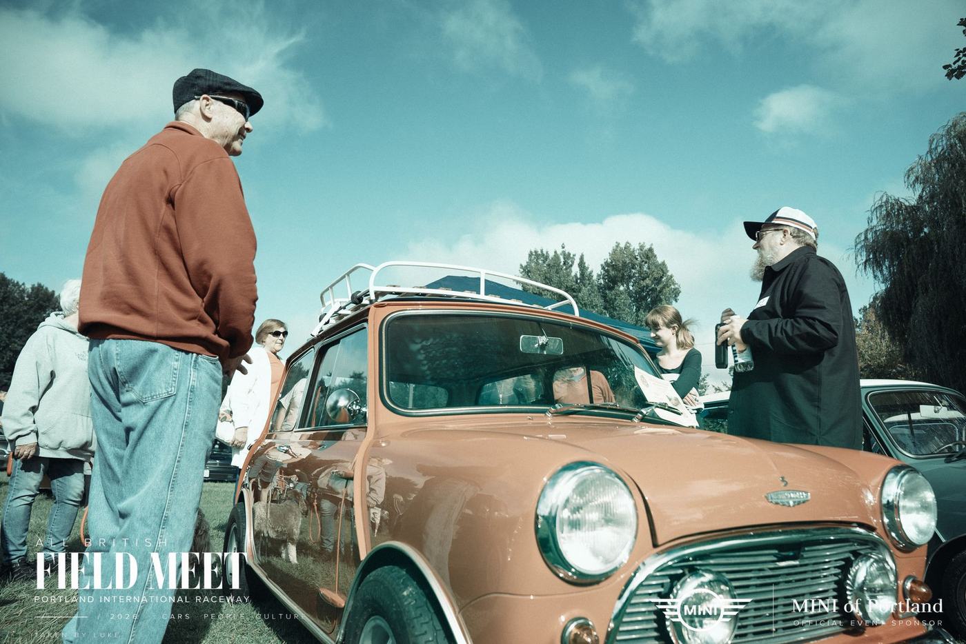 Owners beside an orange Mini