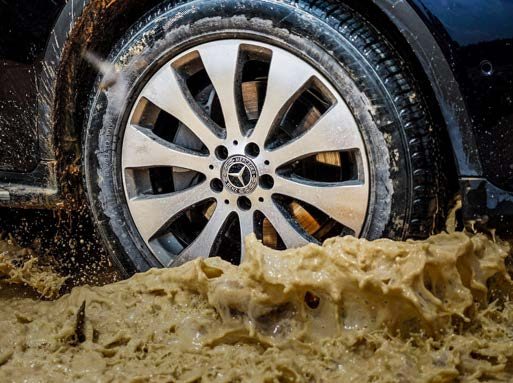 Mercedes-Benz wheel splashing through mud